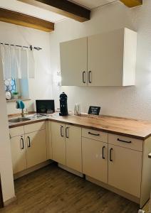 eine Küche mit weißen Schränken und einer Arbeitsplatte in der Unterkunft Gästehaus Goldenes Lamm in Rothenburg ob der Tauber