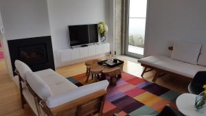 a living room with a couch and a tv at Casa das Boticas in Paredes de Coura