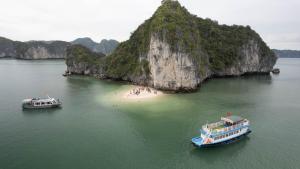 two boats in the water next to a beach at CHÂN TRỜI MỚI -NEW HORIZON HOTEL in Cat Ba