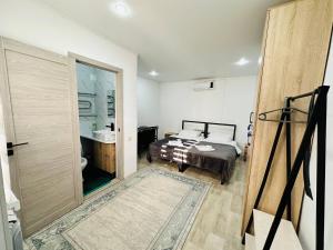 sypialnia z łóżkiem i drzwiami do łazienki w obiekcie Гостевой Дом Guest of Almaty w mieście Ałma-Ata