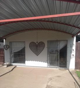 ein Gebäude mit zwei Käfigen mit Herzen an der Wand in der Unterkunft hello honey in Kimberley