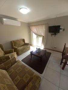 ein Wohnzimmer mit einem Sofa und einem Tisch in der Unterkunft hello honey in Kimberley