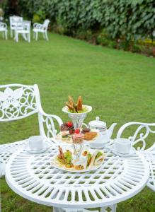 a white table with a plate of food on it at Aaradhya Nuwara Eliya in Nuwara Eliya