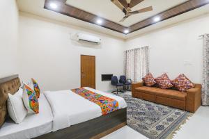 a bedroom with a bed and a couch at FabHotel Sarovar Palace in Muthiganj