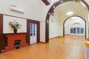 an empty room with a brick fireplace and an archway at FabHotel Sarovar Palace in Muthiganj
