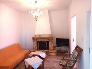 uma sala de estar com um sofá e uma lareira em Holiday House with sea view in Skala Polichnitos em Skála