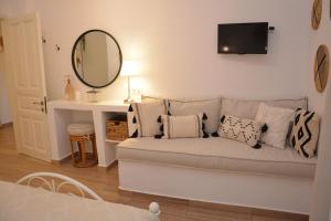 a living room with a couch and a mirror at Patmos Little Suites in Skala