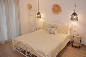 a bedroom with a white bed with two lamps at Patmos Little Suites in Skala