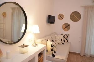 a living room with a mirror and a white couch at Patmos Little Suites in Skala