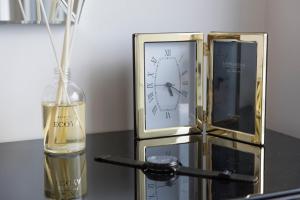 una botella de champán junto a un reloj y una botella de vino en Covent Garden Luxury Retreat en Londres