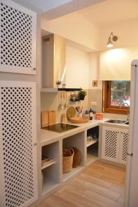 a kitchen with white cabinets and a sink at Patmos Little Suites in Skala