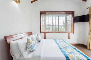 1 dormitorio con cama y ventana en Aaradhya Nuwara Eliya, en Nuwara Eliya