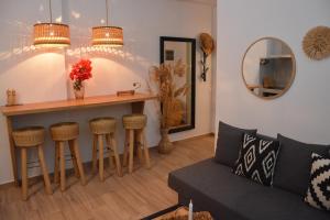 a living room with a couch and a table and a mirror at Patmos Little Suites in Skala