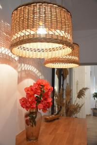 una lámpara de araña con flores rojas en un jarrón sobre una mesa en Patmos Little Suites en Skala