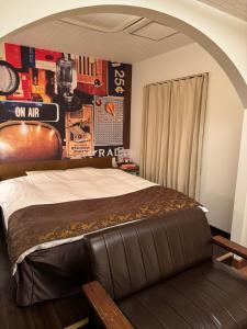 神戶的住宿－拉拉度假村（僅限成人入住），一间卧室配有一张带皮革长凳的床