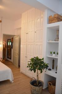 a bedroom with a large white closet with a potted plant at Patmos Little Suites in Skala