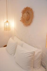 a white bed with white pillows and a mirror on the wall at Patmos Little Suites in Skala