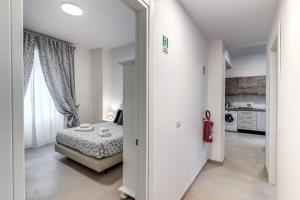 een kleine slaapkamer met een bed en een keuken bij PMT Apt in Rome