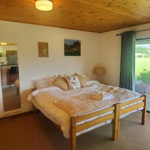 1 dormitorio con 1 cama con techo de madera en Aspen Villa Misty Mountain Studio, en Underberg