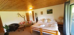 a bedroom with a bed and a living room at Aspen Villa Misty Mountain Studio in Underberg