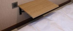 uma prateleira de madeira por cima de uma cama num quarto em Hotel tt Gupo em Busan