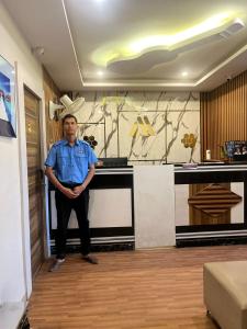 a man standing in front of a kitchen counter at Hotel Avenue Suites Near International Airport Bangalore in Bangalore
