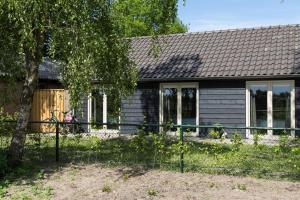 ein kleines Haus mit einem Zaun davor in der Unterkunft De Gemoedelijkheid in Nuenen