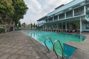 a swimming pool in front of a building at Hotel ayong Linggarjati Kuningan Mitra RedDoorz in Kuningan