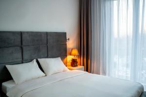 sypialnia z dużym białym łóżkiem i oknem w obiekcie Elegant Living Apartment 2 w mieście Sofia