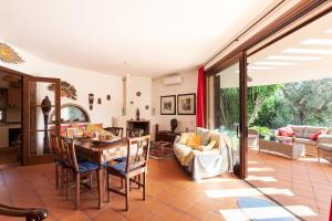 een woonkamer met een houten tafel en stoelen bij Villa Menhir with pool garden and tennis - Happy Rentals in Tuglie