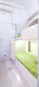 a white bunk bed with a green bedspread with sheep at HR's Residence in Boracay