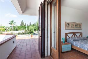 une cuisine avec une porte s'ouvrant sur une terrasse avec un lit dans l'établissement Villa Menhir with pool garden and tennis - Happy Rentals, à Tuglie