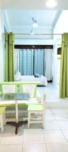 Zimmer mit einem Tisch, Stühlen und einem Bett in der Unterkunft HR's Residence in Boracay