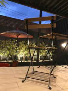 un supporto metallico con ombrellone su un patio di LaLa Resort (Adult Only) a Kobe