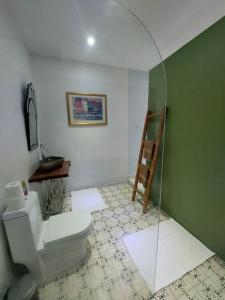 bagno con servizi igienici e parete verde di RAYA by Snooze a Yogyakarta
