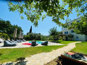 a pool with chairs and umbrellas next to a house at Cottage with Private Pool in Poros