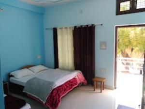 a bedroom with a bed in a blue room at Hotel Vikram Palace Sapeta in Barkot