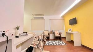 a room with a white and yellow wall at Swing & Pillows - KL Cheras Maluri in Kuala Lumpur