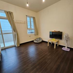 an empty living room with a flat screen tv at Maybe Homestay in Longjing