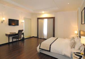 1 dormitorio con 1 cama y escritorio con ordenador en Hotel Blue Saphire Countryside Haldwani, en Haldwāni