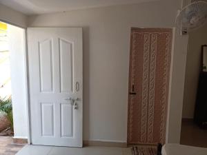 an empty room with a white door next to a door at Royal Touch Beach Huts in Palolem