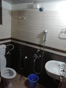 a bathroom with a toilet and a sink at Royal Touch Beach Huts in Palolem