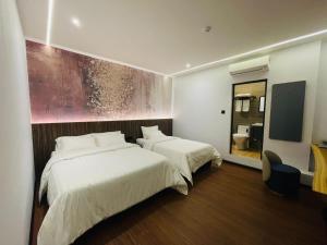 a hotel room with two beds and a tv at Cyther Stay Hotel in Tawau