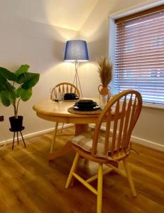 a dining room table with two chairs and a lamp at Central Crewe - Modern 1BR Haven in Crewe
