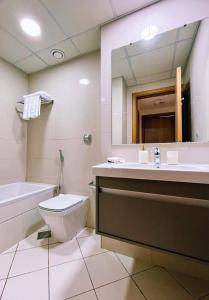 a bathroom with a toilet and a sink and a mirror at Lux High Rise Marina Apartment in Dubai