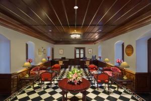 a lobby with red chairs and tables in a building at Welcomhotel by ITC Hotels, The Savoy, Mussoorie in Mussoorie