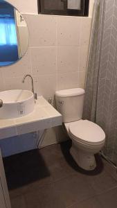 La salle de bains est pourvue de toilettes blanches et d'un lavabo. dans l'établissement The Monkey Resort Donheang, à Prachuap Khiri Khan