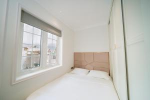 a small bedroom with a bed and a window at The Nguyens - Pink Church View in Ho Chi Minh City