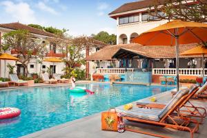uma mulher está numa piscina num resort em Ronil Goa - a JdV by Hyatt Hotel em Calangute