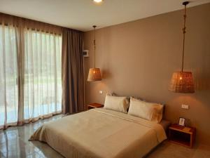 a bedroom with a large bed and two lamps at Koh Kood Club in Ko Kood